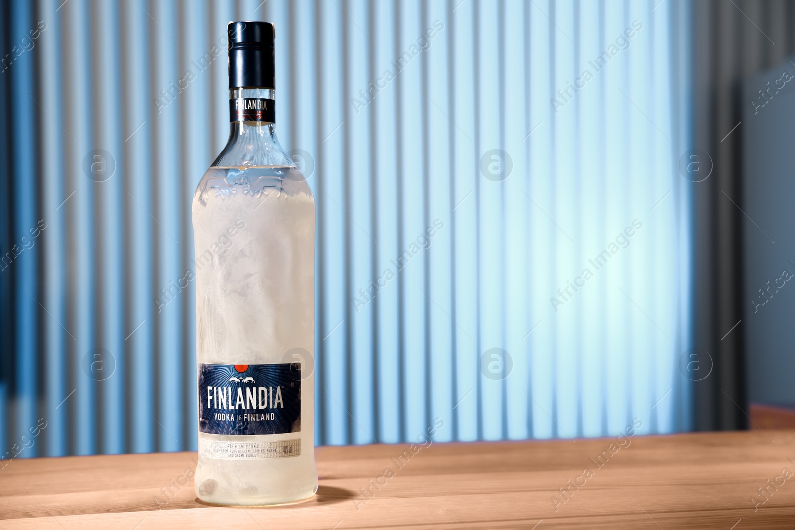 Photo of MYKOLAIV, UKRAINE - SEPTEMBER 23, 2019: Bottle of Finlandia vodka on wooden bar counter. Space for text