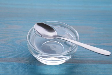 Photo of Bowl of fructose syrup on light blue wooden table