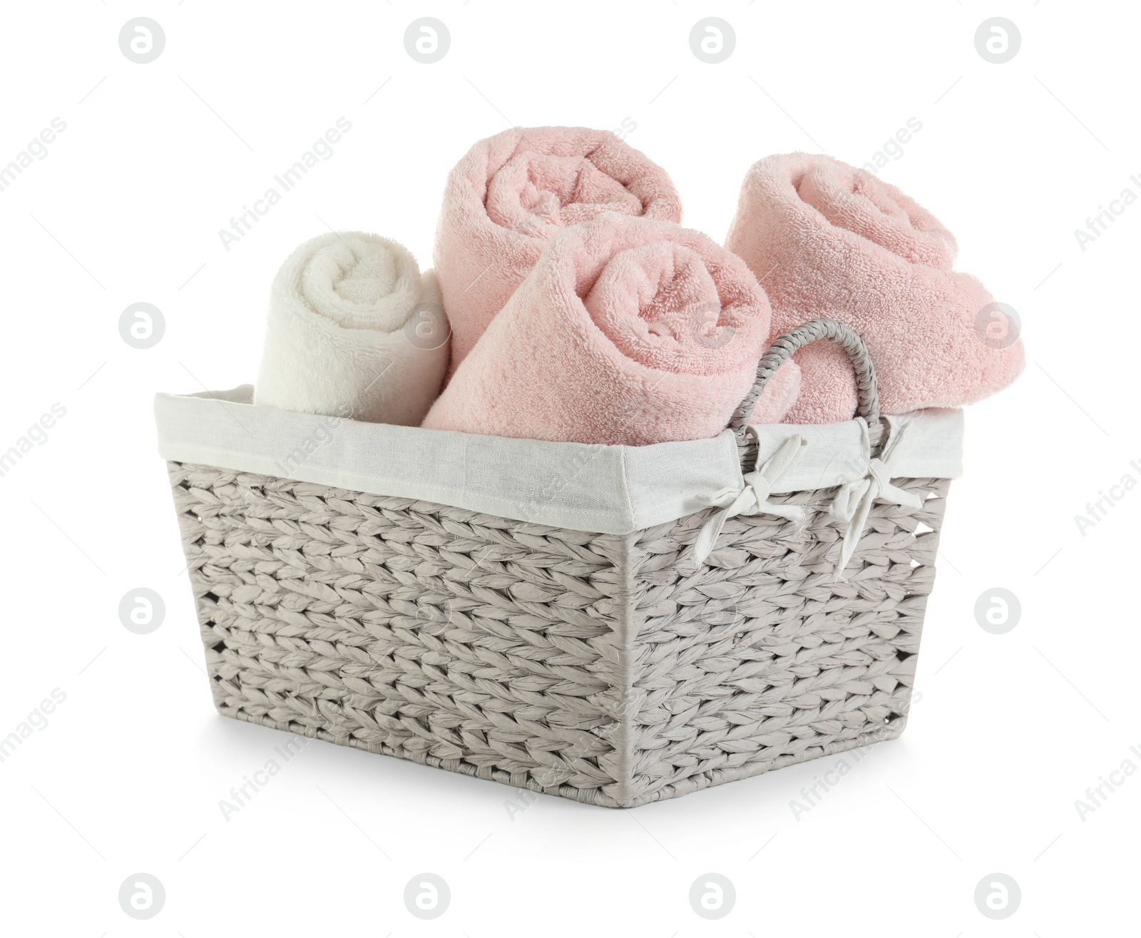 Photo of Rolled soft towels in basket on white background