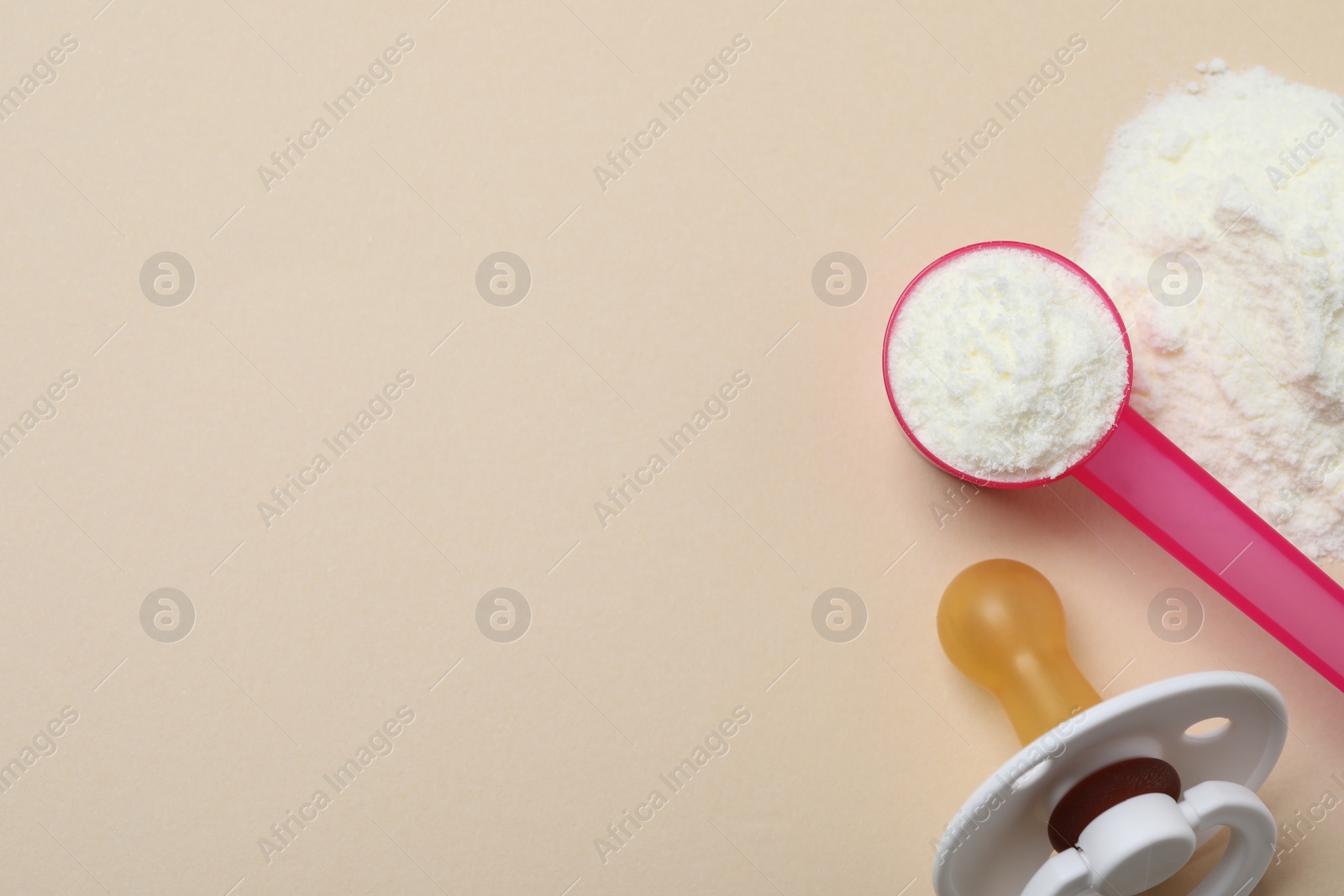 Photo of Flat lay of powdered infant formula with scoop and pacifier on beige background, space for text. Baby milk