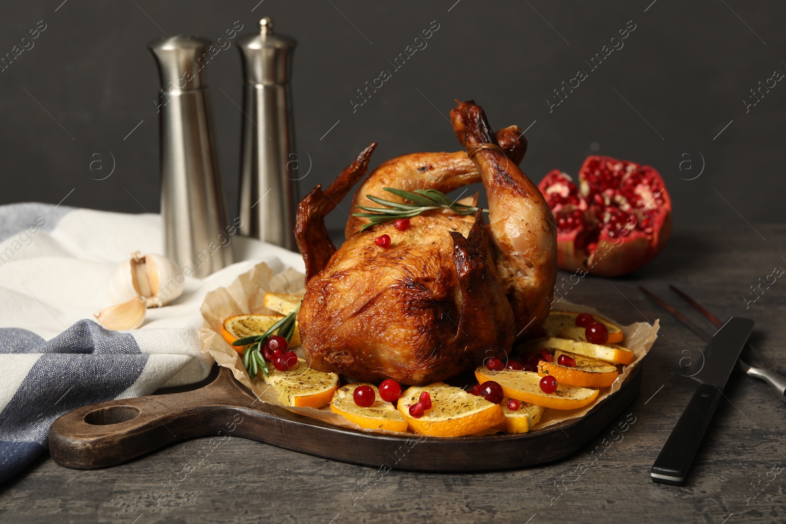 Photo of Baked chicken with orange slices on grey table