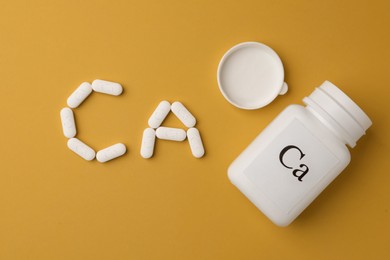 Photo of Calcium supplement pills and jar on yellow background, flat lay