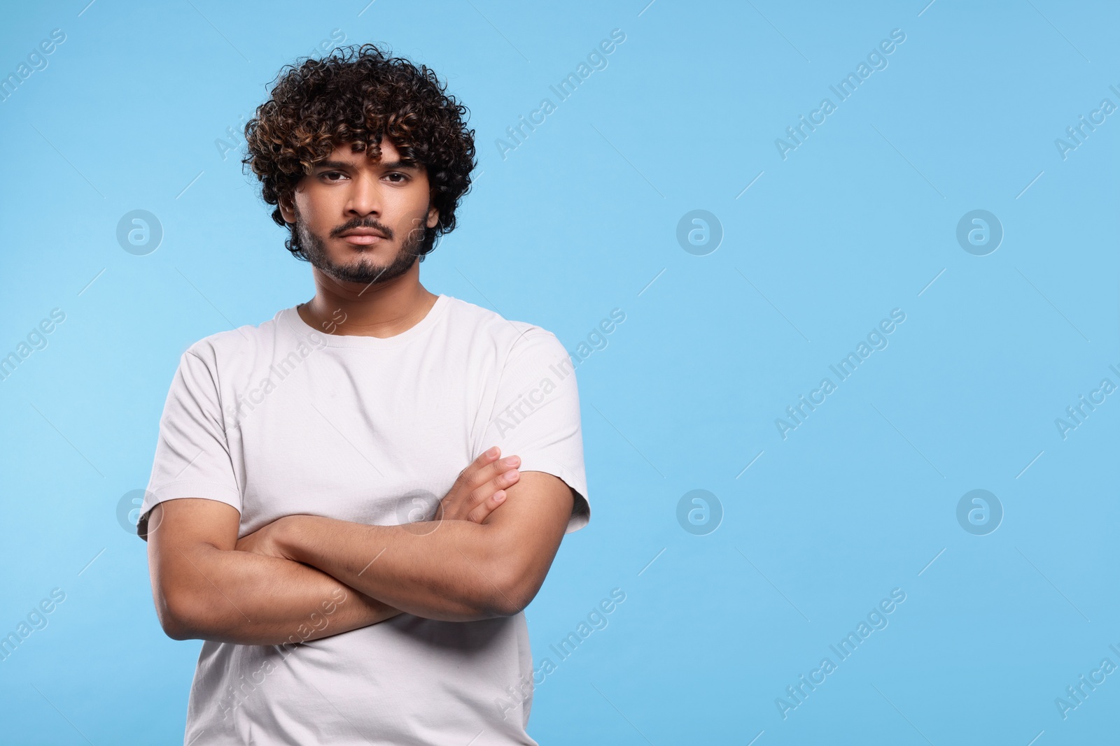 Photo of Handsome young man on light blue background, space for text