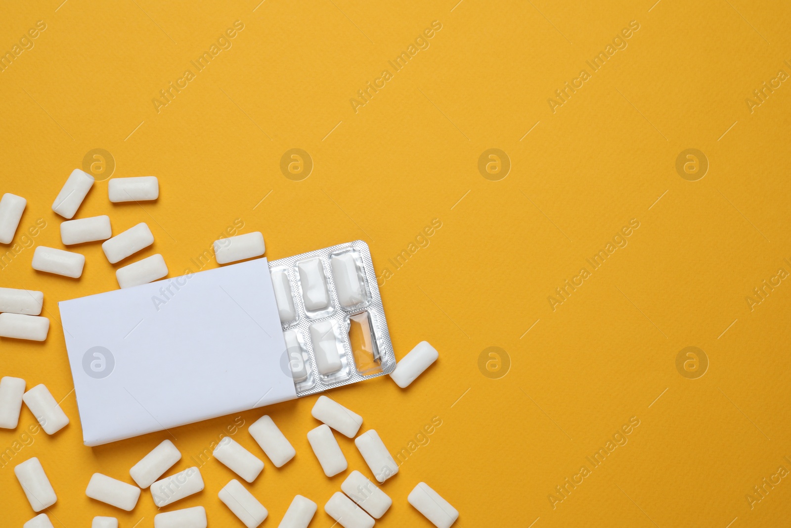 Photo of Pack with tasty chewing gums on orange background, flat lay. Space for text