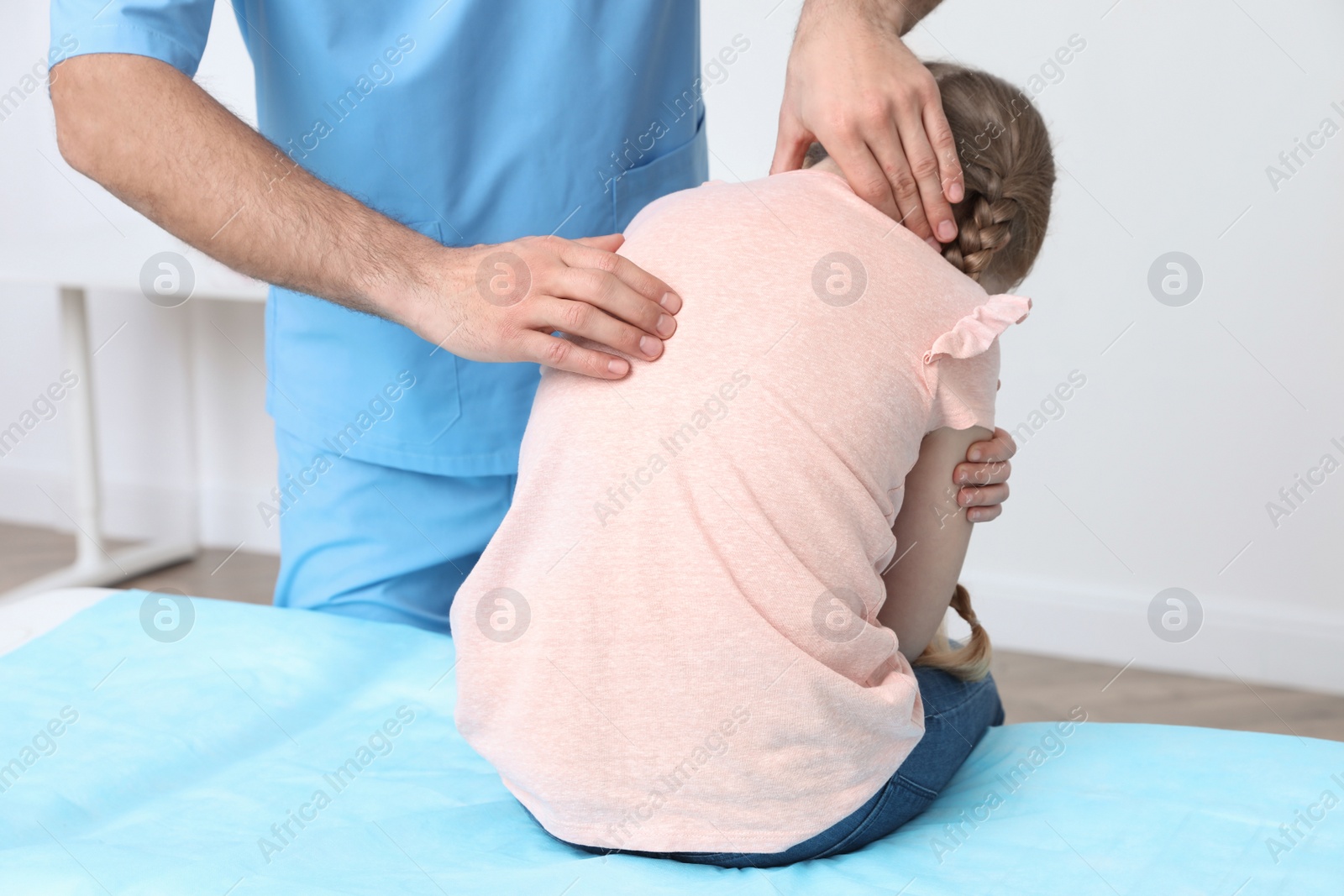 Photo of Orthopedist examining child's back in clinic, closeup. Scoliosis treatment