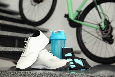 Bicycle gloves, shoes and bottle on stairs at home