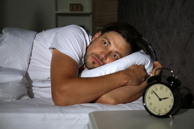 Man suffering from insomnia in bed at home