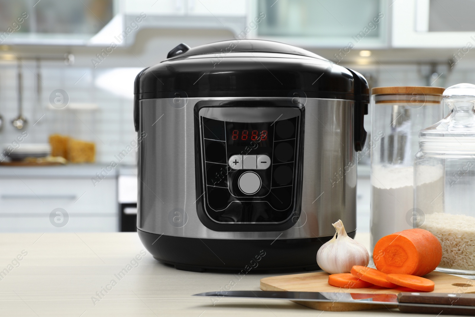 Photo of Modern multi cooker and products on table in kitchen