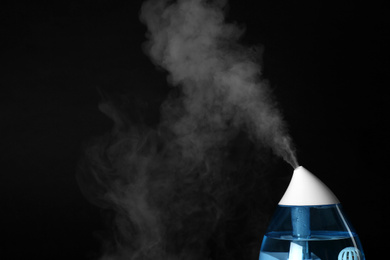 Photo of Modern air humidifier on black background, closeup. Space for text