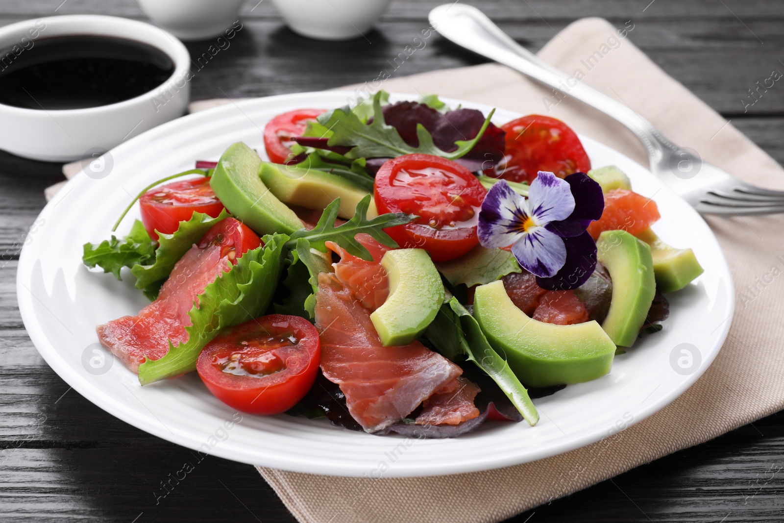 Photo of Tasty vegetable salad with soy sauce served on wooden table, closeup