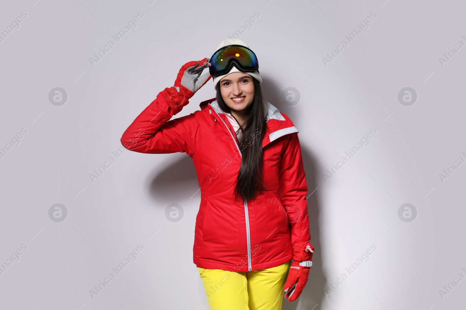 Photo of Woman wearing stylish winter sport clothes on light grey background