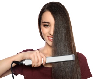 Happy woman using hair iron on white background