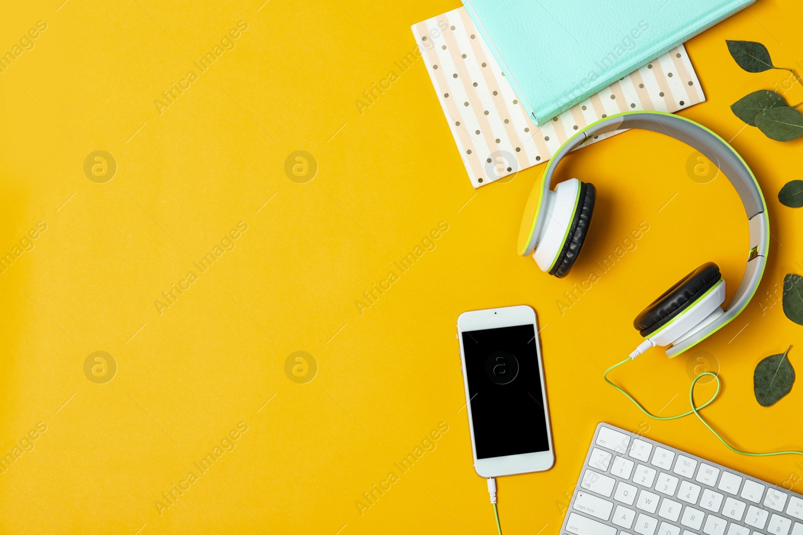 Photo of Flat lay composition with smartphone, computer keyboard, headphones and space for text on color background