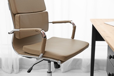 Photo of Modern office chair in stylish workplace interior