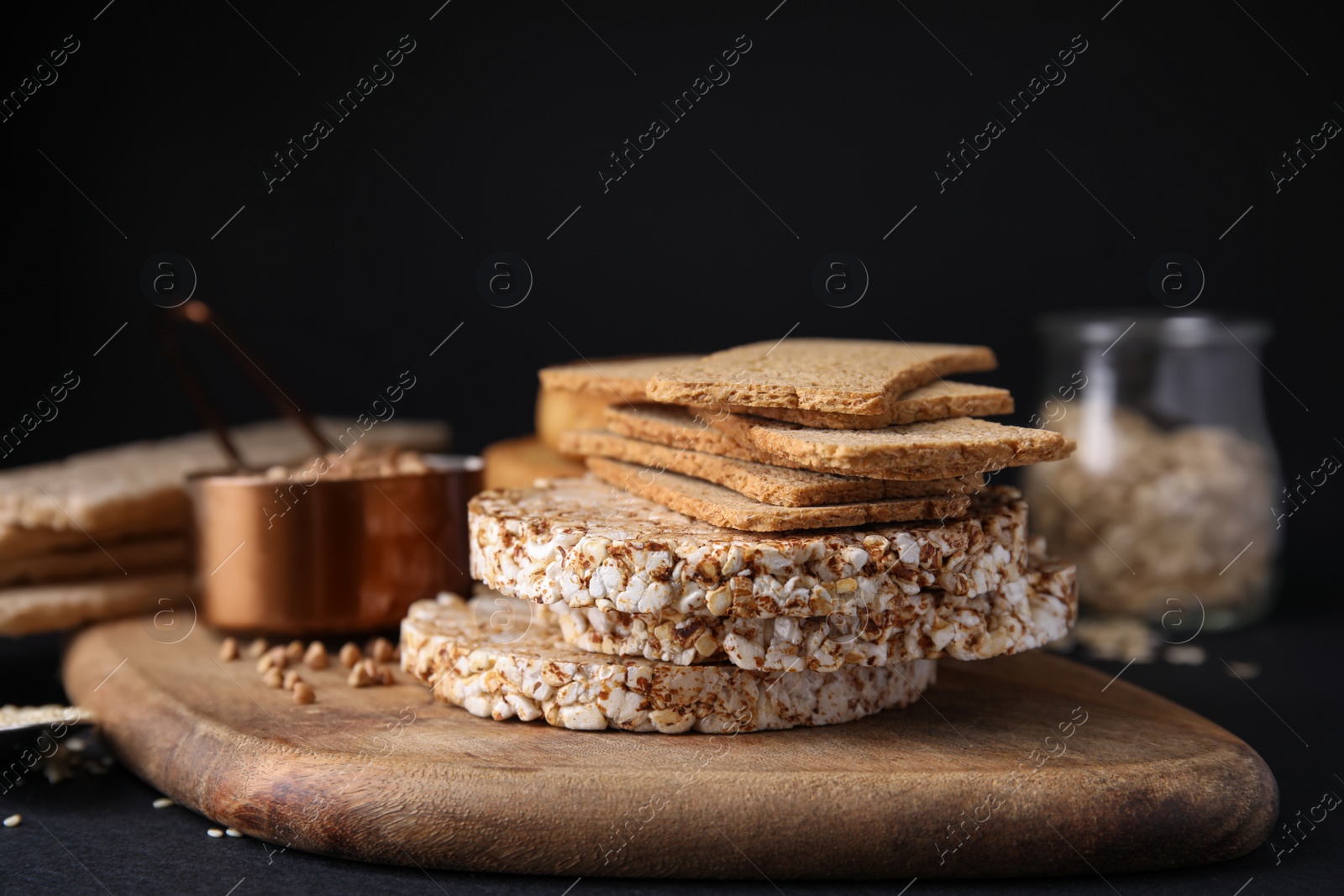 Photo of Rye crispbreads, rice cakes and rusks on black table