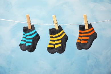 Photo of Different child socks on laundry line against color background