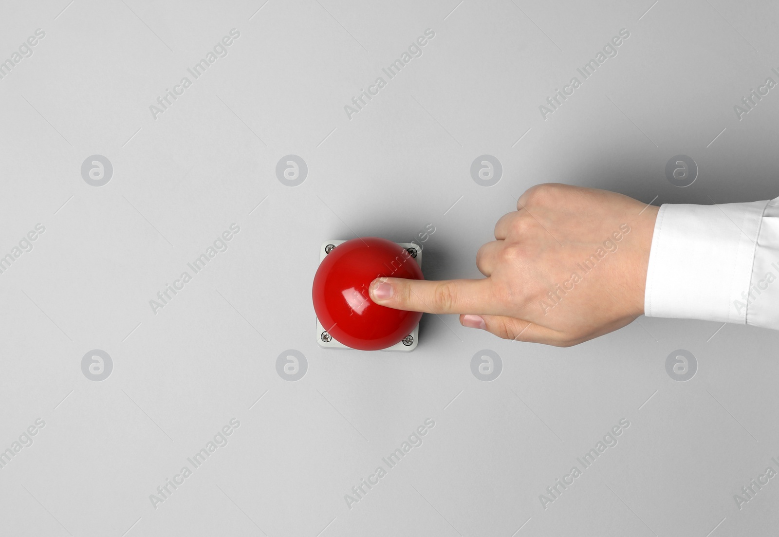 Photo of Man pressing red button of nuclear weapon on light gray background, top view with space for text. War concept