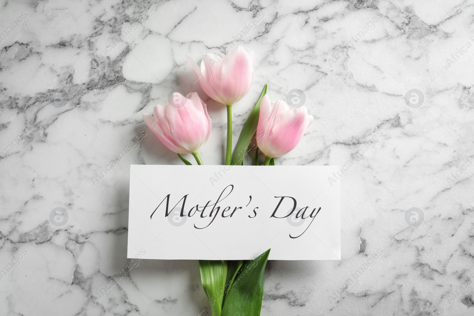 Photo of Beautiful tulips and greeting card with words "Mother's Day" on marble background, top view