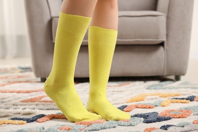 Photo of Woman in stylish yellow socks indoors, closeup