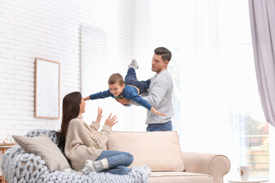 Photo of Happy family with little son having fun at home. Winter vacation