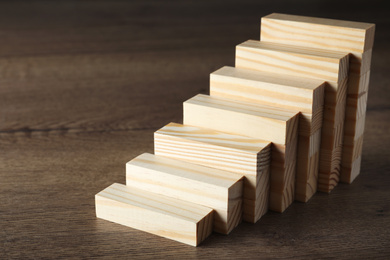 Photo of Steps made with blocks on wooden table. Career ladder