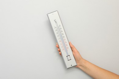 Photo of Woman with weather thermometer on white background, closeup. Space for text