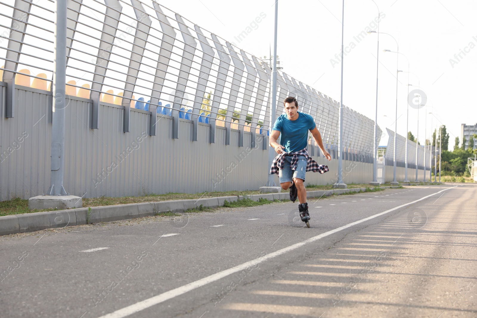 Photo of Handsome young man roller skating outdoors. Recreational activity