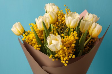 Photo of Bouquet of beautiful spring flowers near turquoise wooden wall, closeup