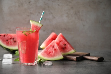 Photo of Glass of tasty refreshing drink with watermelon on grey table. Space for text