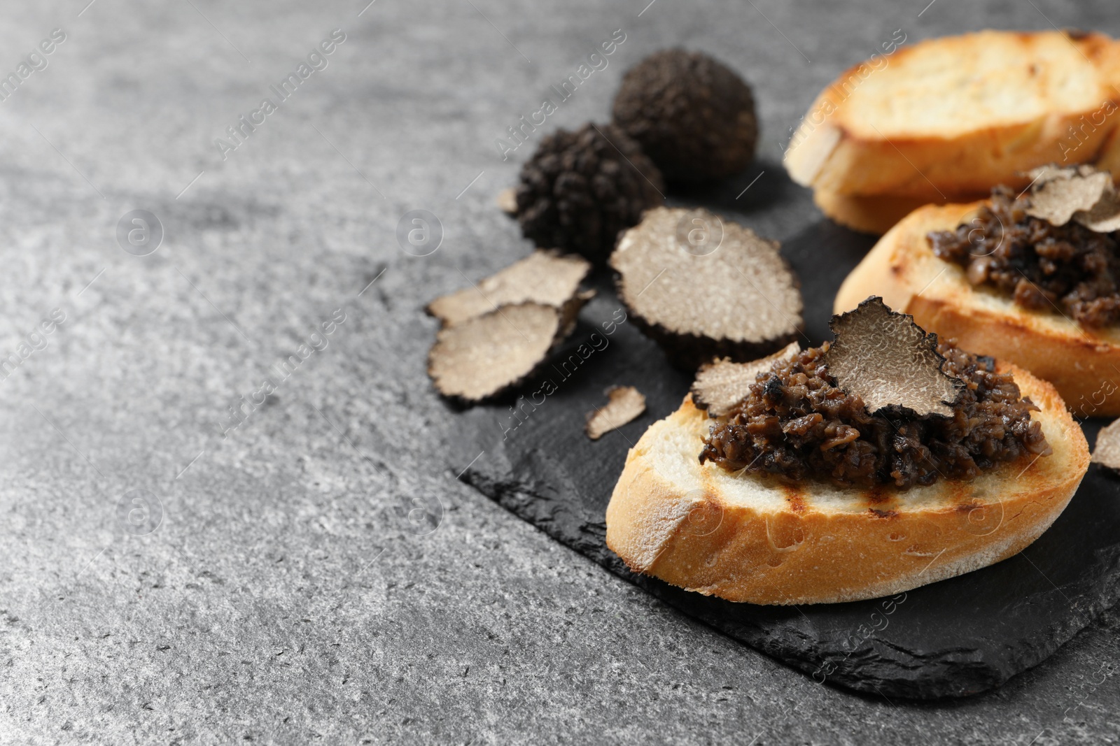 Photo of Delicious bruschettas with truffle sauce on grey table, closeup. Space for text