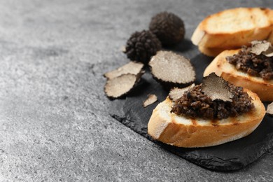 Photo of Delicious bruschettas with truffle sauce on grey table, closeup. Space for text