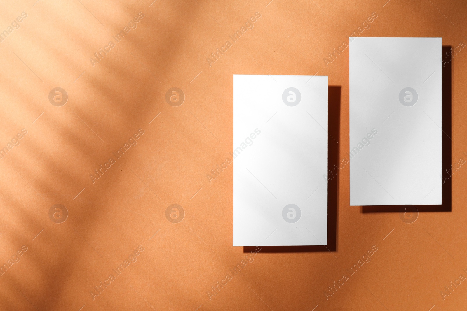 Photo of Empty business card on light brown background, top view. Space for text. Mockup for design