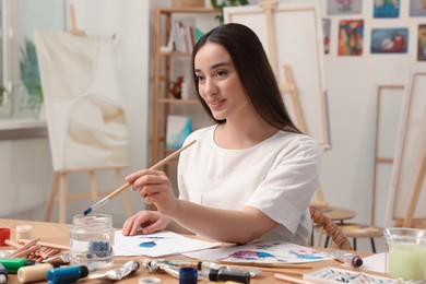 Beautiful young woman painting in studio. Creative hobby