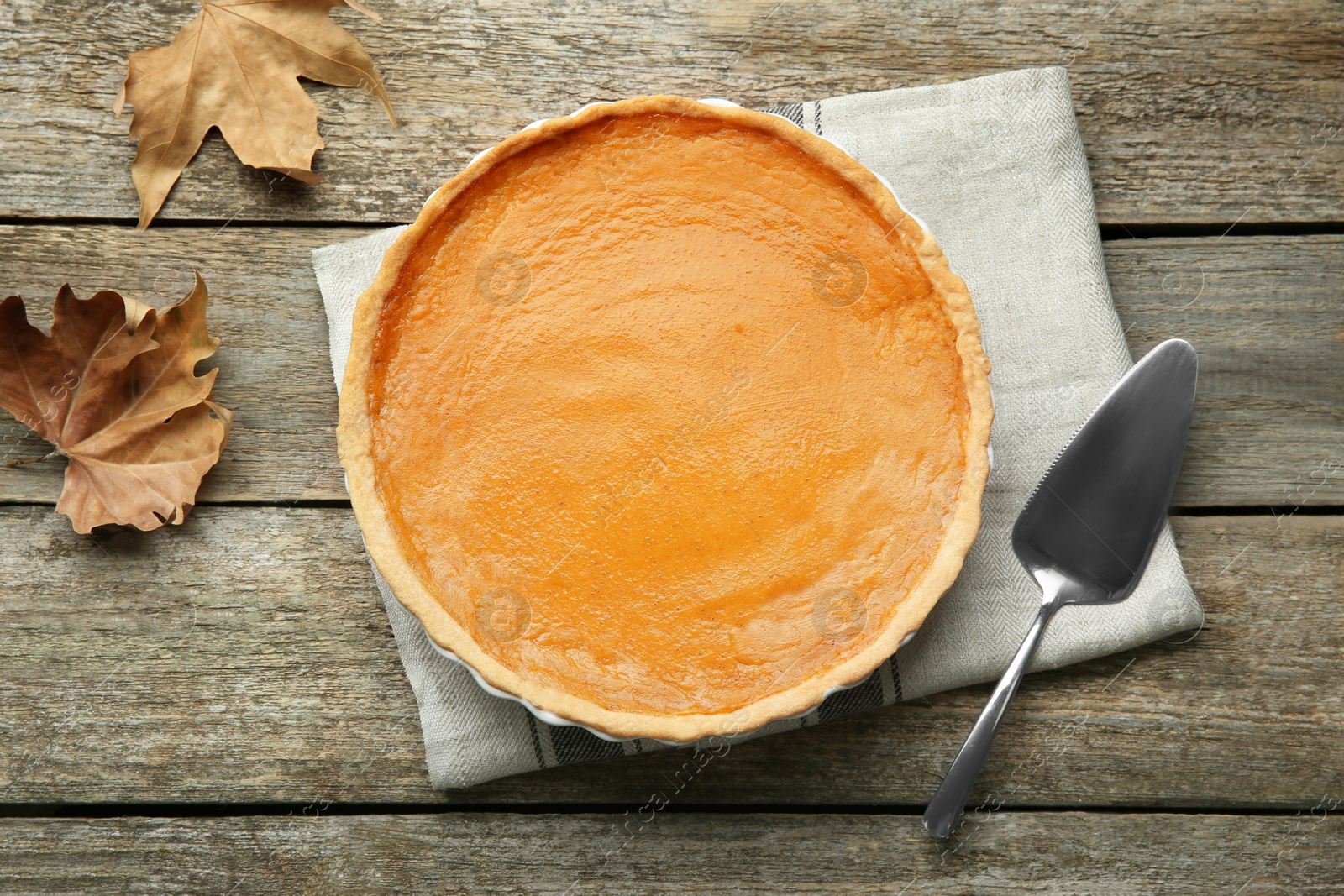 Photo of Delicious fresh pumpkin pie on wooden table, flat lay