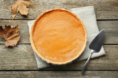 Photo of Delicious fresh pumpkin pie on wooden table, flat lay