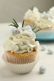 Tasty Easter cupcake with vanilla cream on light wooden table