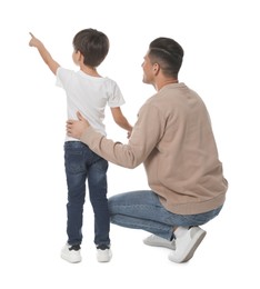 Photo of Little boy with his father on white background, back view