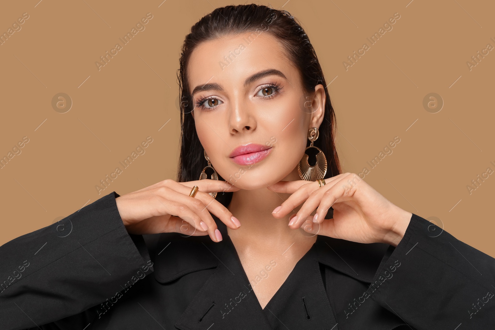 Photo of Portrait of young woman with beautiful makeup on light brown background