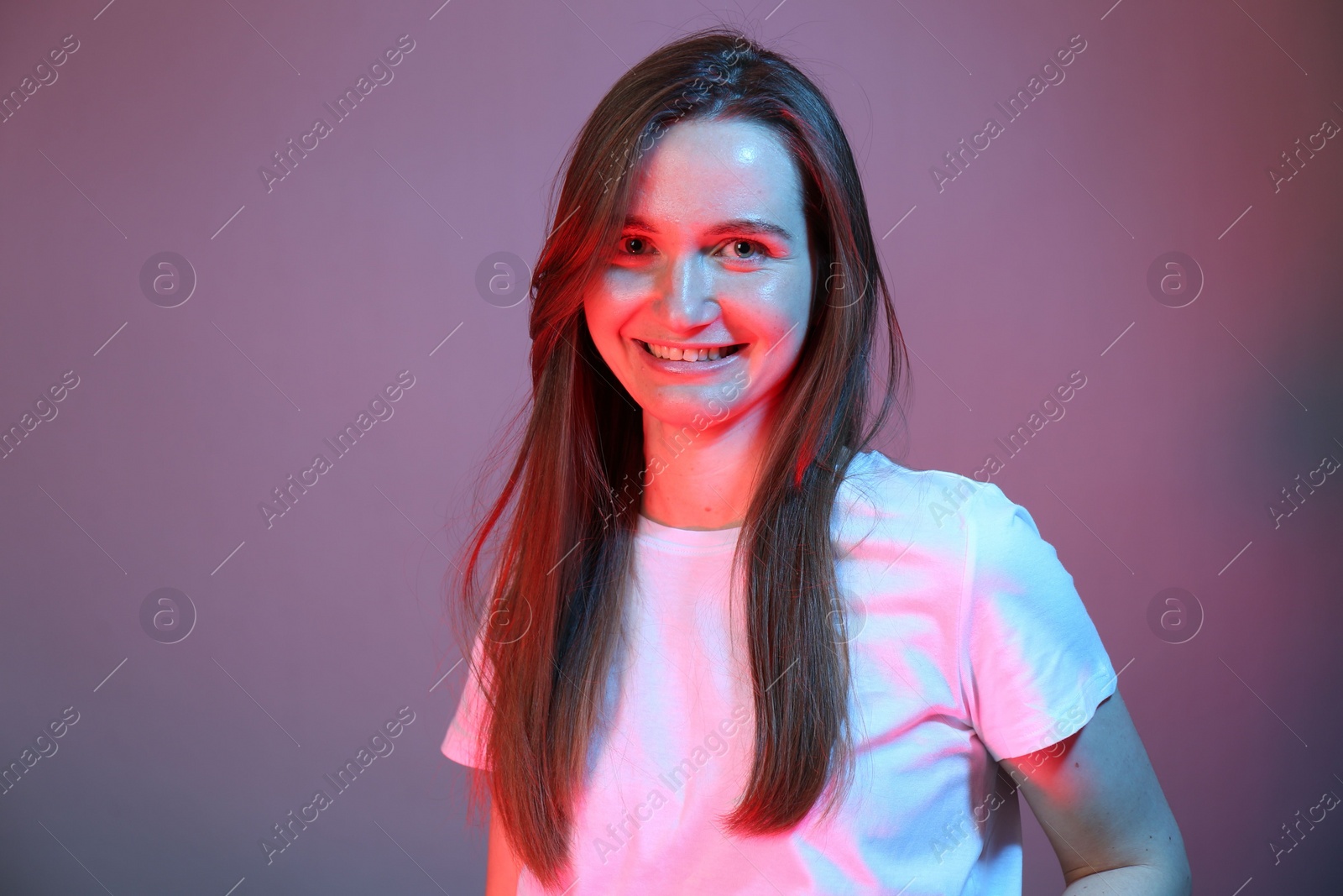 Photo of Portrait of beautiful woman in neon lights on color background