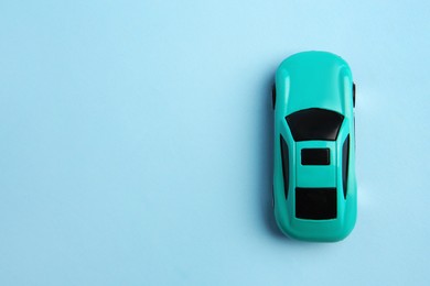 Photo of One bright car on light blue background, top view with space for text. Children`s toy