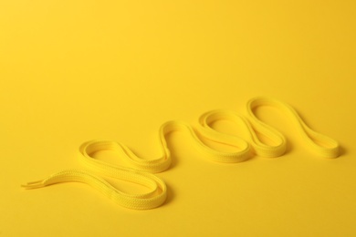 Shoe lace on yellow background. Space for text
