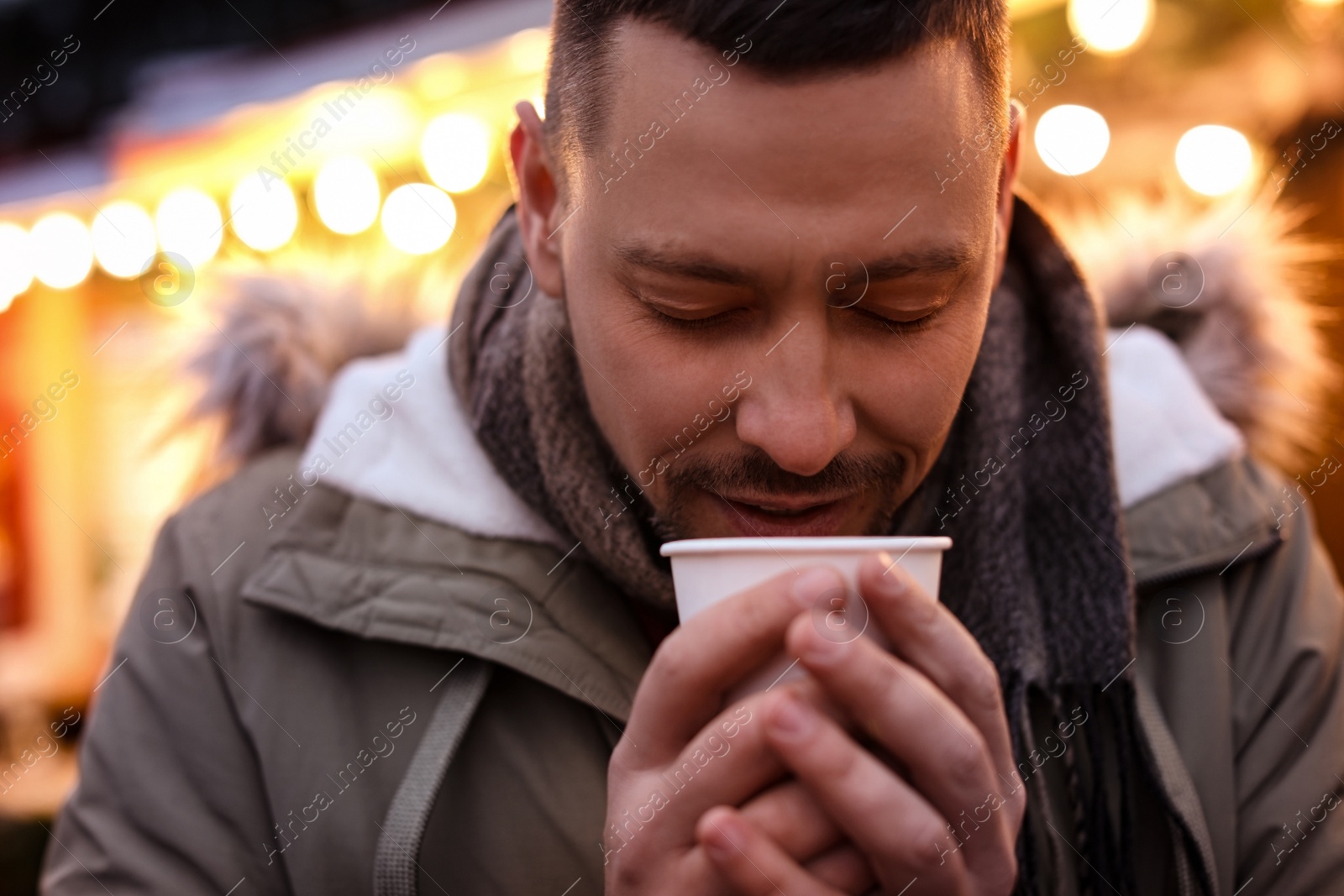 Photo of Happy man with mulled wine at winter fair