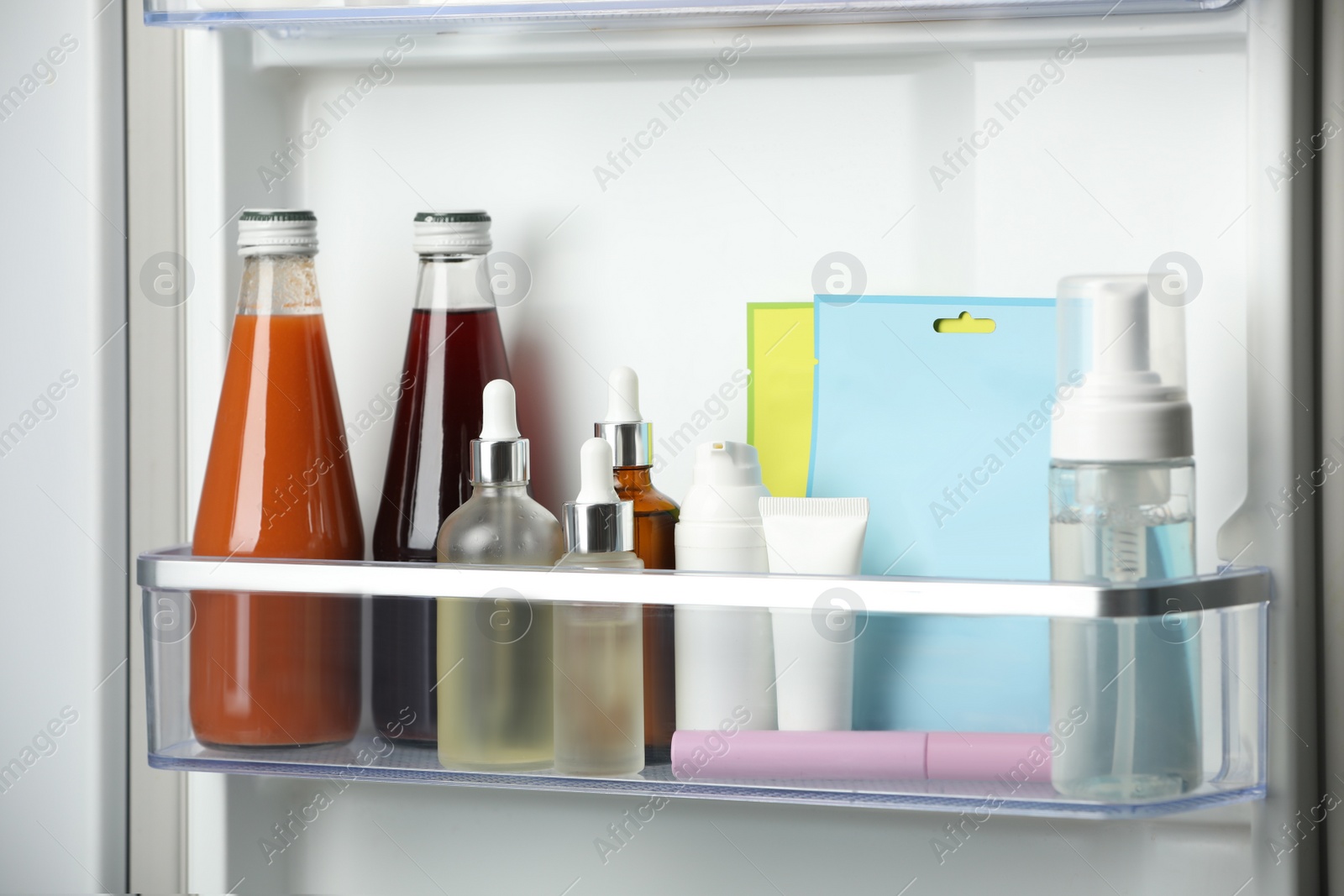 Photo of Different cosmetic products on shelf in refrigerator