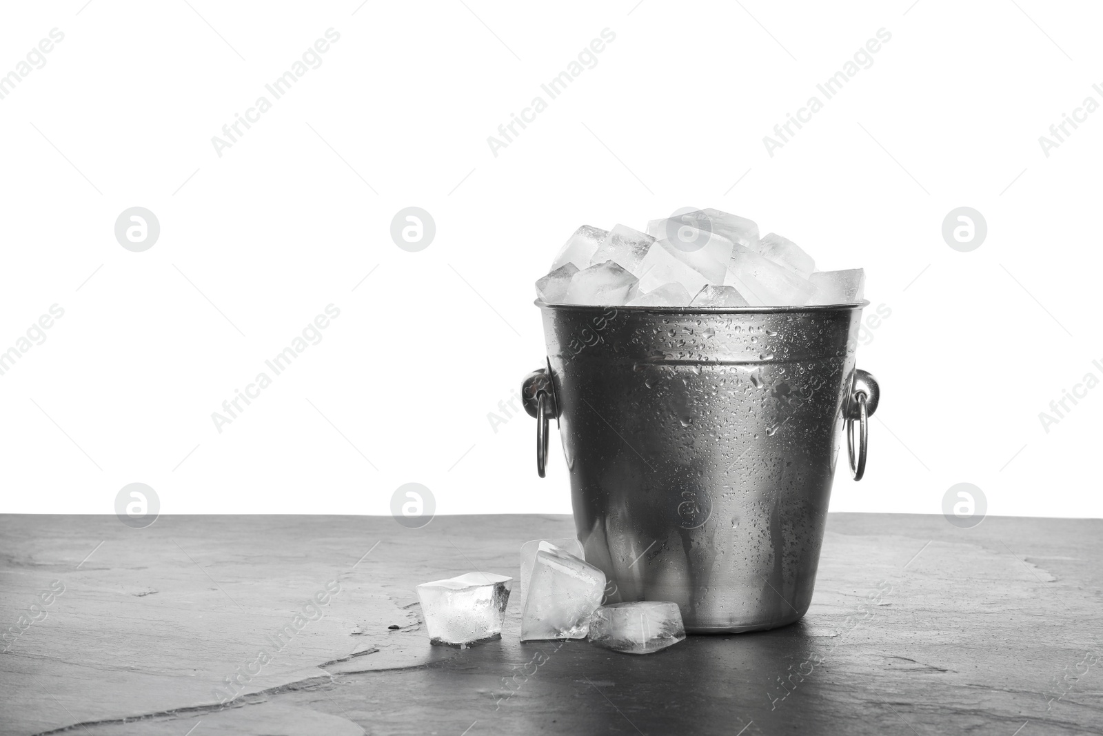 Photo of Metal bucket with ice cubes on table against white background