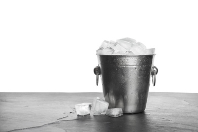 Photo of Metal bucket with ice cubes on table against white background