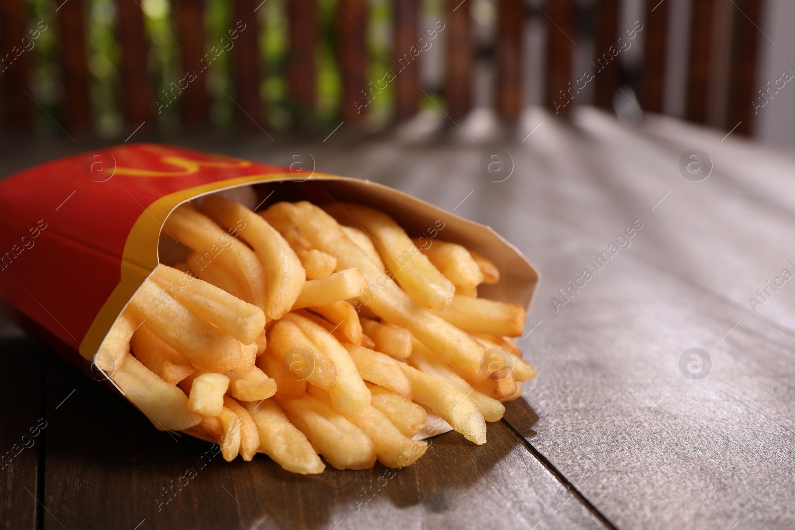 Photo of MYKOLAIV, UKRAINE - AUGUST 12, 2021: Big portion of McDonald's French fries on wooden table, closeup
