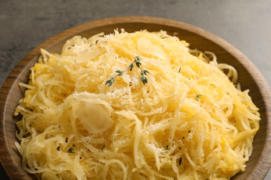 Photo of Bowl with cooked spaghetti squash on gray table