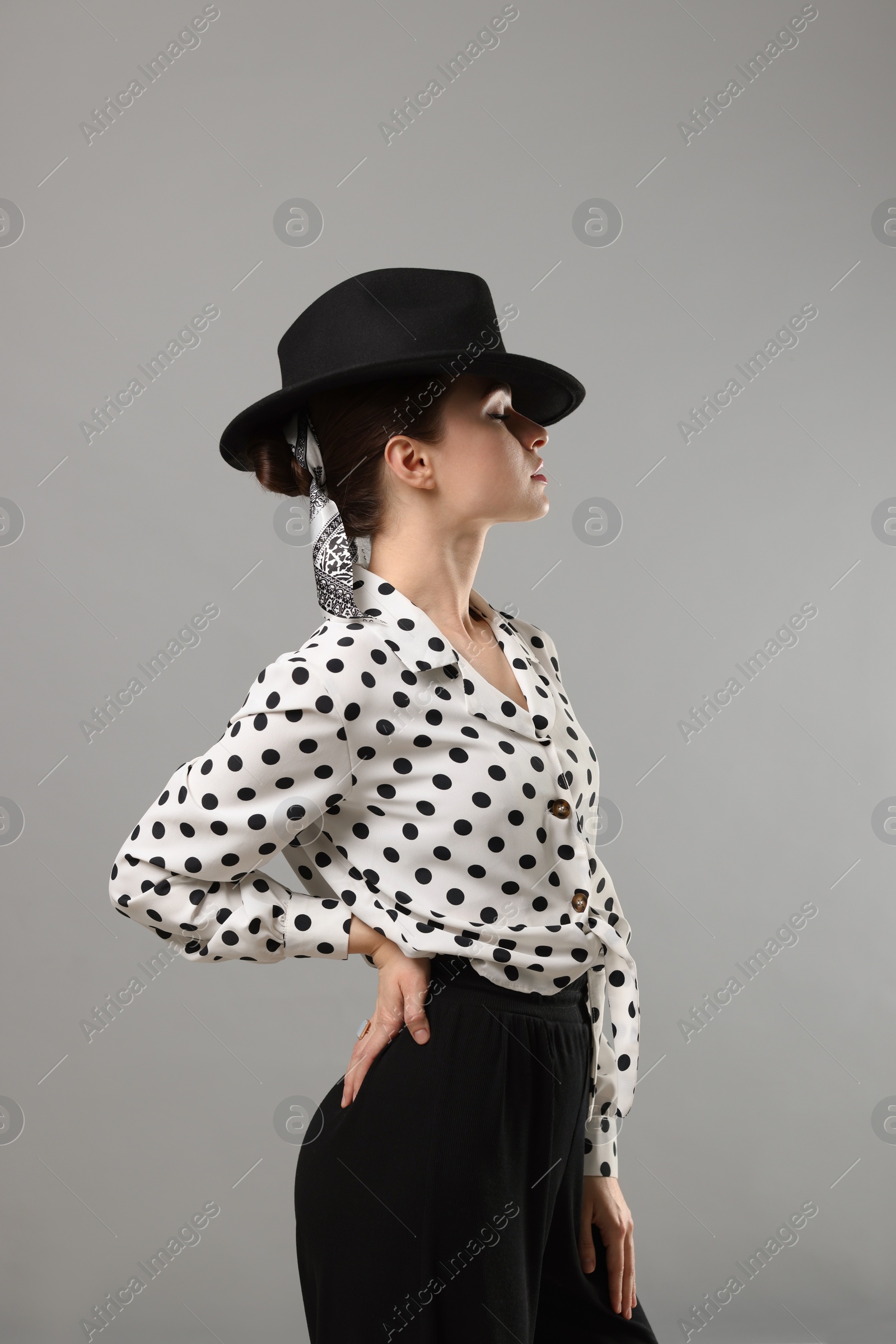 Photo of Woman with black hat and stylish bandana on light grey background