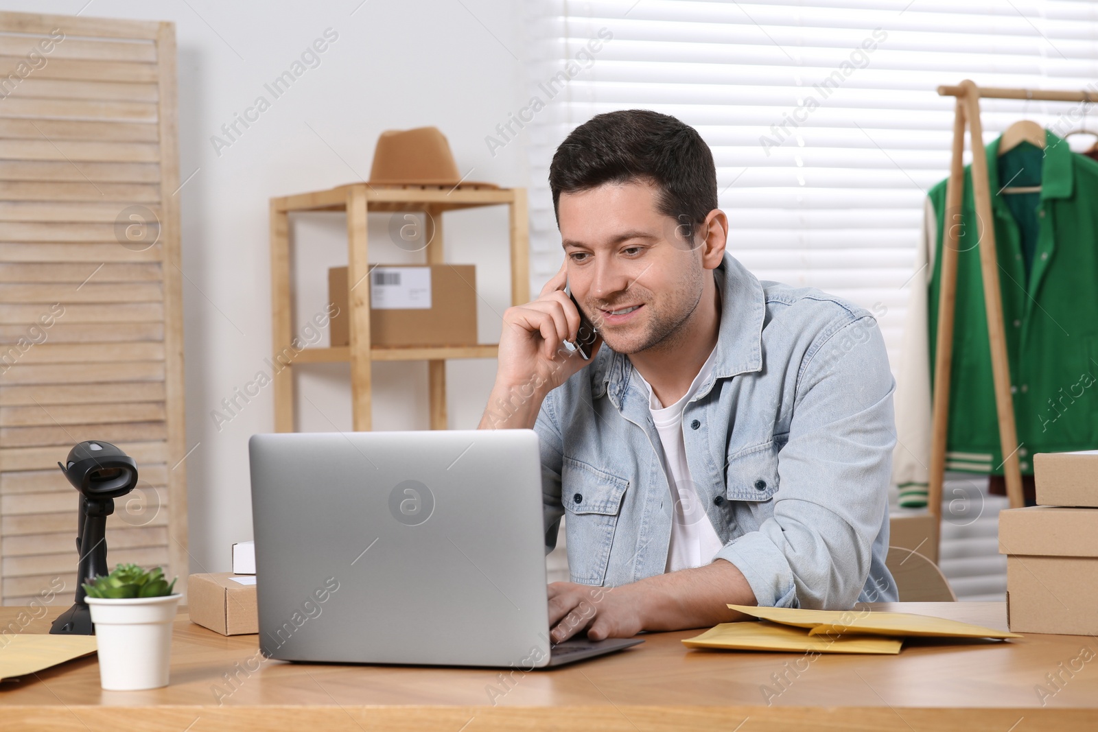 Photo of Seller talking on phone while working in office. Online store