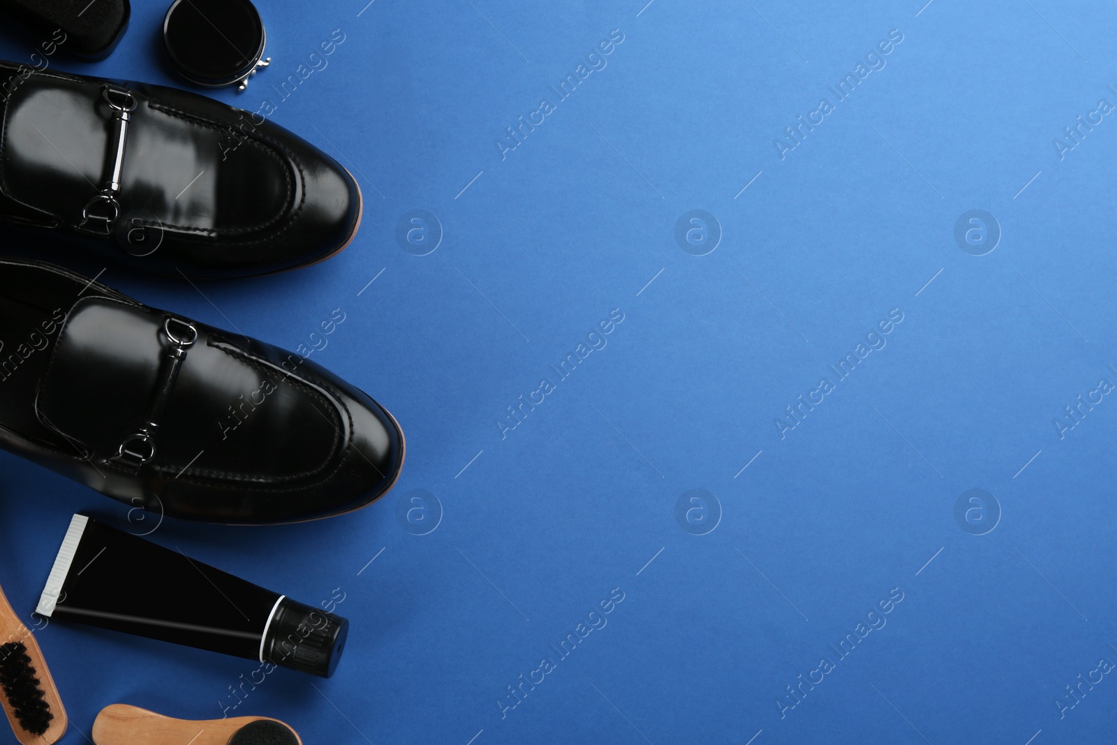 Photo of Flat lay composition with shoe care accessories and footwear on blue background. Space for text